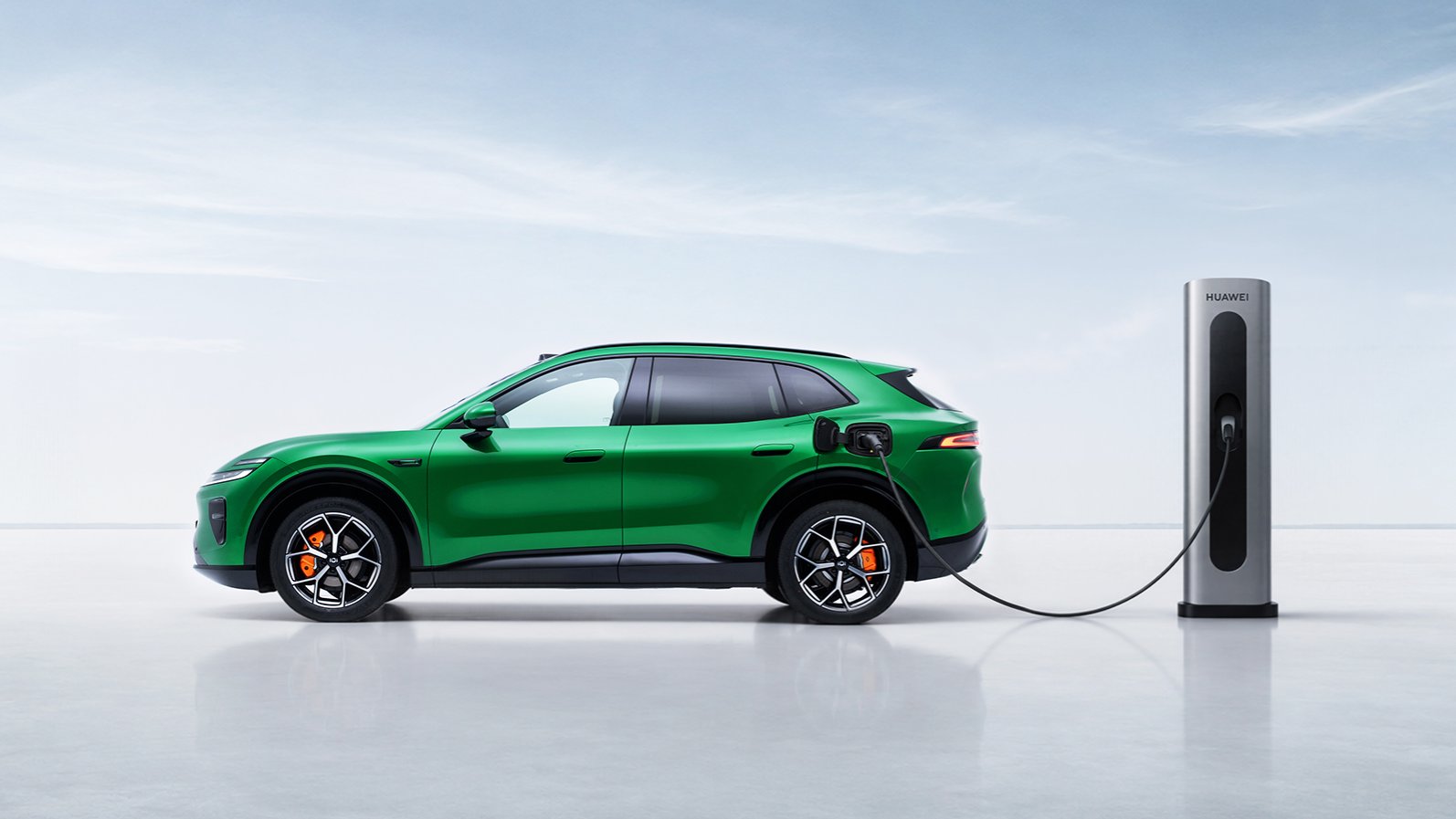 Green Changan Nevo Q06 SUV connected to a charging station, shown in side profile.