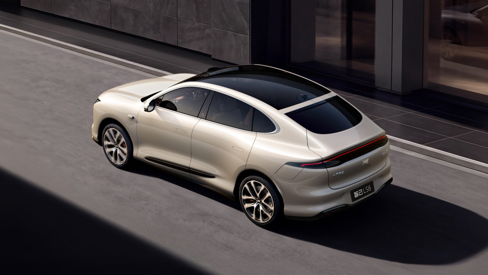 Silver IM Motors LS6 viewed from a rear three-quarter angle, showing its panoramic glass roof and full-width taillight.